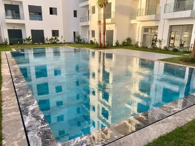 a swimming pool in front of a building at Studio cosy in Nouaceur