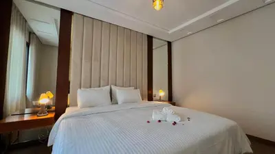 a bedroom with a large white bed with two lamps at D2 L'Art de Vivre Urbain au Cœur de Casablanca maarif in Casablanca