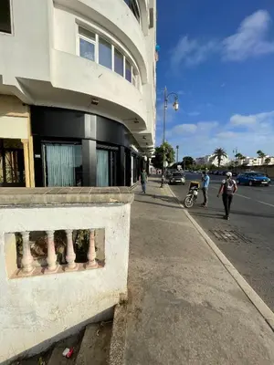 a man walking down a street next to a building at Chambre Privée en plein centre de Rabat Agdal in Rabat