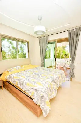 a bedroom with a large bed in a room with windows at Modern Marina - Beach - Pool in Sidi Rahal