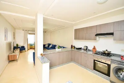 a kitchen and living room with a stove top oven at Modern Marina - Beach - Pool in Sidi Rahal