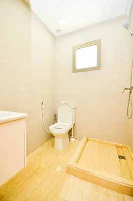 a bathroom with a toilet and a sink and a window at Modern Marina - Beach - Pool in Sidi Rahal