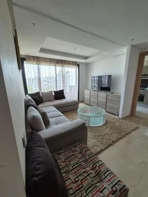 a living room with a couch and a glass table at My Cosy Place - Apartment 2BR - Piscine -Résidence Marbella Hay Riad in Rabat