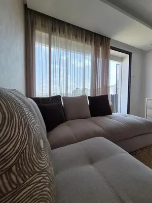 a living room with a couch and a large window at My Cosy Place - Apartment 2BR - Piscine -Résidence Marbella Hay Riad in Rabat