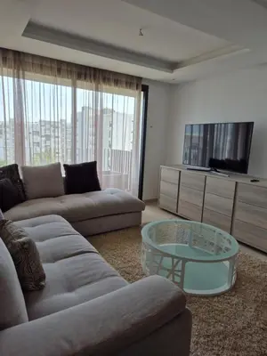 a living room with a couch and a glass table at My Cosy Place - Apartment 2BR - Piscine -Résidence Marbella Hay Riad in Rabat