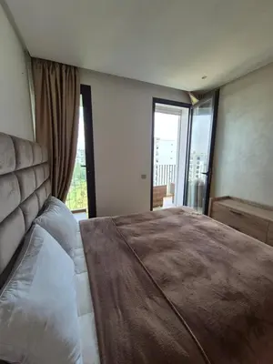 a bedroom with a large bed with a large window at My Cosy Place - Apartment 2BR - Piscine -Résidence Marbella Hay Riad in Rabat