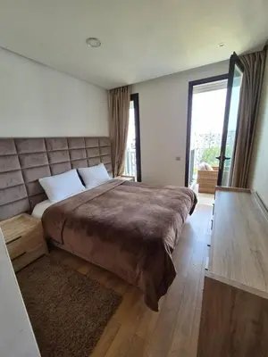 a bedroom with a large bed and a large window at My Cosy Place - Apartment 2BR - Piscine -Résidence Marbella Hay Riad in Rabat
