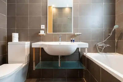a bathroom with a sink and a tub and a toilet at Résidence Luxe avec Plage Privée in Bouznika