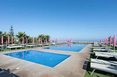 a row of chairs and a pool at a resort at Résidence Luxe avec Plage Privée in Bouznika
