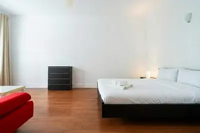 a bedroom with a bed and a red couch at Résidence Luxe avec Plage Privée in Bouznika