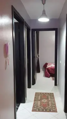 a hallway with black doors and a rug on the floor at Appartement entier Familial Tamaris-Dar Bouazza-Casablanca in Dar Bouazza