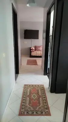a hallway with a rug and a couch in a room at Appartement entier Familial Tamaris-Dar Bouazza-Casablanca in Dar Bouazza