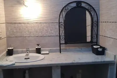 a bathroom with a sink and a mirror at Appartement entier Familial Tamaris-Dar Bouazza-Casablanca in Dar Bouazza