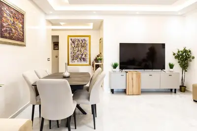 a dining room with a table and chairs and a tv at Joli appartement 2 chambres in Casablanca
