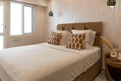 a bedroom with a large bed with white sheets and pillows at Joli appartement 2 chambres in Casablanca