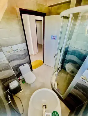 a bathroom with a shower and a white toilet at Confort Moderne à 2 Pas de la Mer Calme Absolu in Dar Bouazza