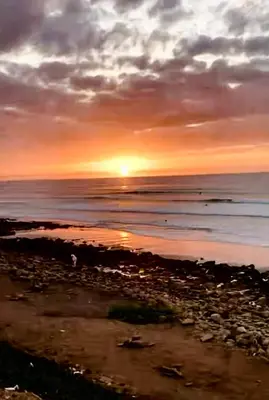a sunset over the ocean with the sun setting at Confort Moderne à 2 Pas de la Mer Calme Absolu in Dar Bouazza