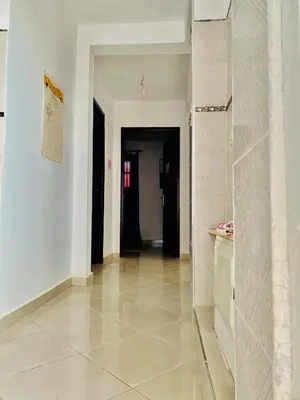 a hallway with white walls and a tile floor at Confort Moderne à 2 Pas de la Mer Calme Absolu in Dar Bouazza