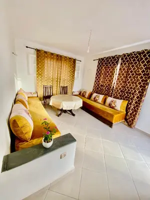 a living room with a couch and a table at Confort Moderne à 2 Pas de la Mer Calme Absolu in Dar Bouazza