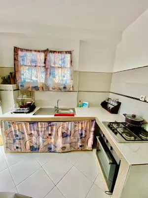 a small kitchen with a sink and a stove at Confort Moderne à 2 Pas de la Mer Calme Absolu in Dar Bouazza
