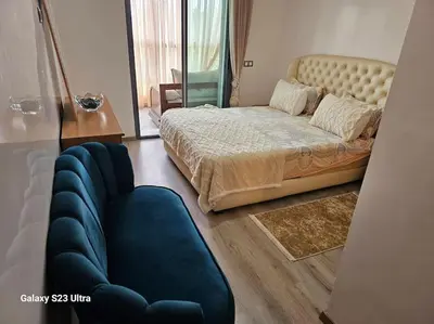 a bedroom with a large bed and a blue couch at Studio a Mohammedia pied dans l'eau in Mohammedia