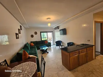 a living room with a green couch and a table at Studio a Mohammedia pied dans l'eau in Mohammedia