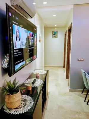 a living room with a tv on a wall at Beachside Apartment in Mohammedia