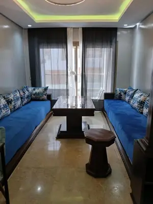a living room with blue couches and a table at Beachside Apartment in Mohammedia