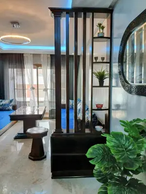 a living room with a couch and a table and some plants at Beachside Apartment in Mohammedia