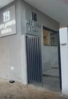 a building with a door with a sign on it at Élégance Urbaine Casa Finance city in LʼOasis