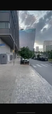 a city street with a tree and a building at Élégance Urbaine Casa Finance city in LʼOasis