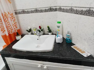a white sink on a black counter in a bathroom at Happy House in Océan