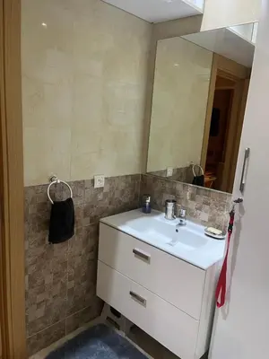 a bathroom with a white sink and a mirror at Résidence kettani piscine bouznika in Bouznika