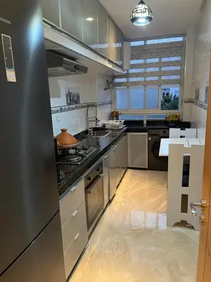 a kitchen with stainless steel appliances and a large window at Résidence kettani piscine bouznika in Bouznika