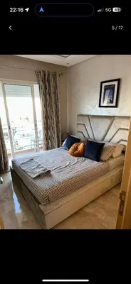 a bedroom with a large bed with blue pillows at Bouznika, Shems Kettani in Bouznika