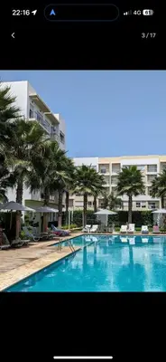 a large swimming pool with palm trees and a building at Bouznika, Shems Kettani in Bouznika