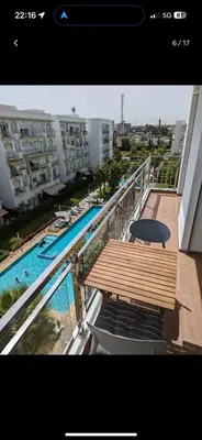 a balcony with a table and a swimming pool at Bouznika, Shems Kettani in Bouznika