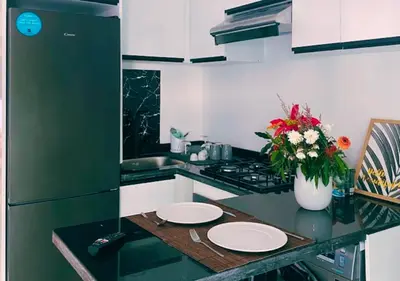 a kitchen with a counter with plates and a vase of flowers at Chic Urban Studio - Maarif Casablanca - Walk to Twin Center in Casablanca