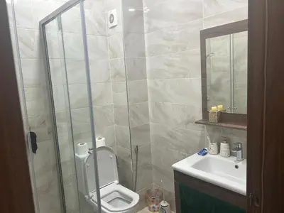 a bathroom with a shower and a toilet and a sink at Appartement location in Bouznika