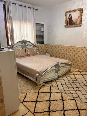 a bedroom with a bed and a rug at Maison wafaa in O Ben Slimane