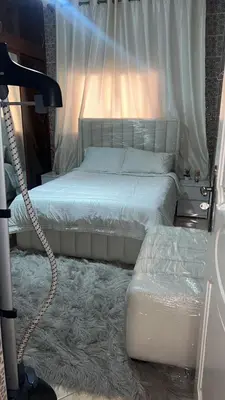 a bedroom with a bed with a lamp and a carpet at Maison wafaa in O Ben Slimane