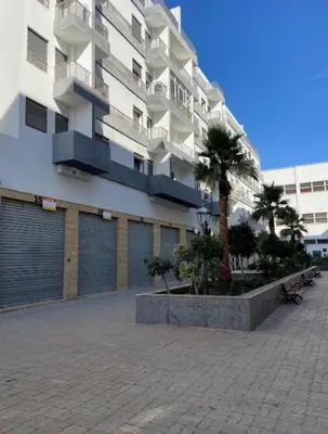 a large apartment building with palm trees in front of it at Studio charme à prix doux in Casablanca