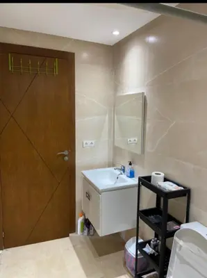 a bathroom with a sink and a wooden door at Studio charme à prix doux in Casablanca