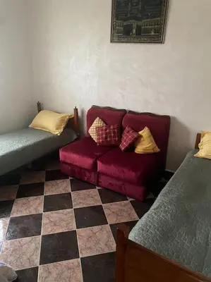 a living room with a couch and a checkered floor at Villa Casablanca-Sidi Rahal à 5 min de la plage in Sidi Rahal