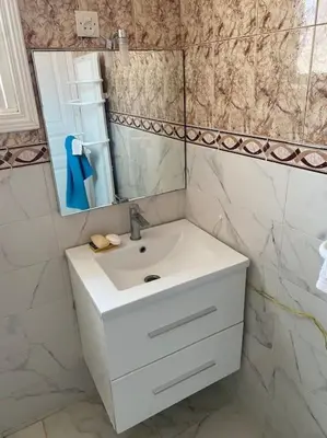 a bathroom with a white sink and a mirror at Villa Casablanca-Sidi Rahal à 5 min de la plage in Sidi Rahal