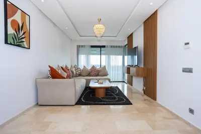 a living room with a couch and a table at Appartement Royal in Beni Brour