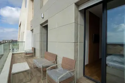 a balcony with two chairs on top of a building at Appartement Royal in Beni Brour
