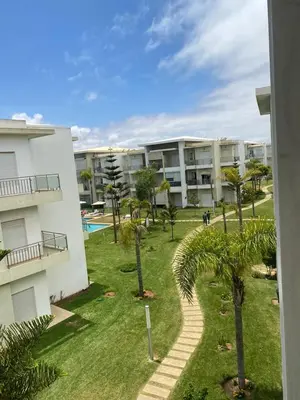 an apartment building with a yard with palm trees at Casabay sidirehal in Sidi Rahal