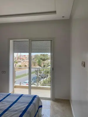a bedroom with a bed and a sliding glass door at Casabay sidirehal in Sidi Rahal