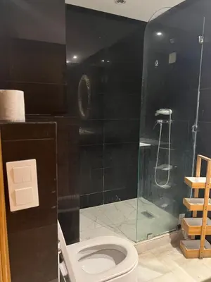 a bathroom with a toilet and a glass shower at Residence le 11 in Casablanca